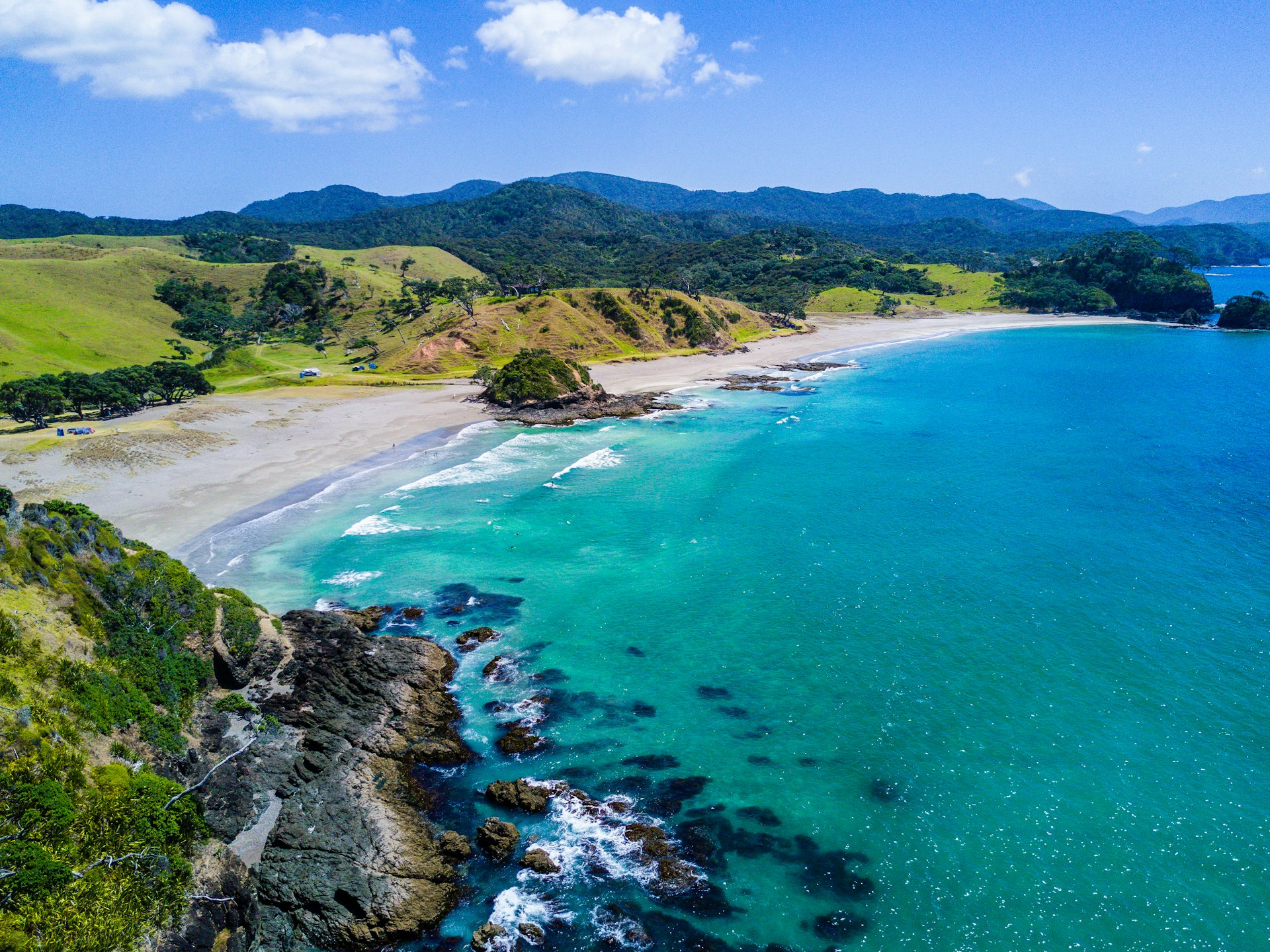 Vista aérea da praia entre morros verdes